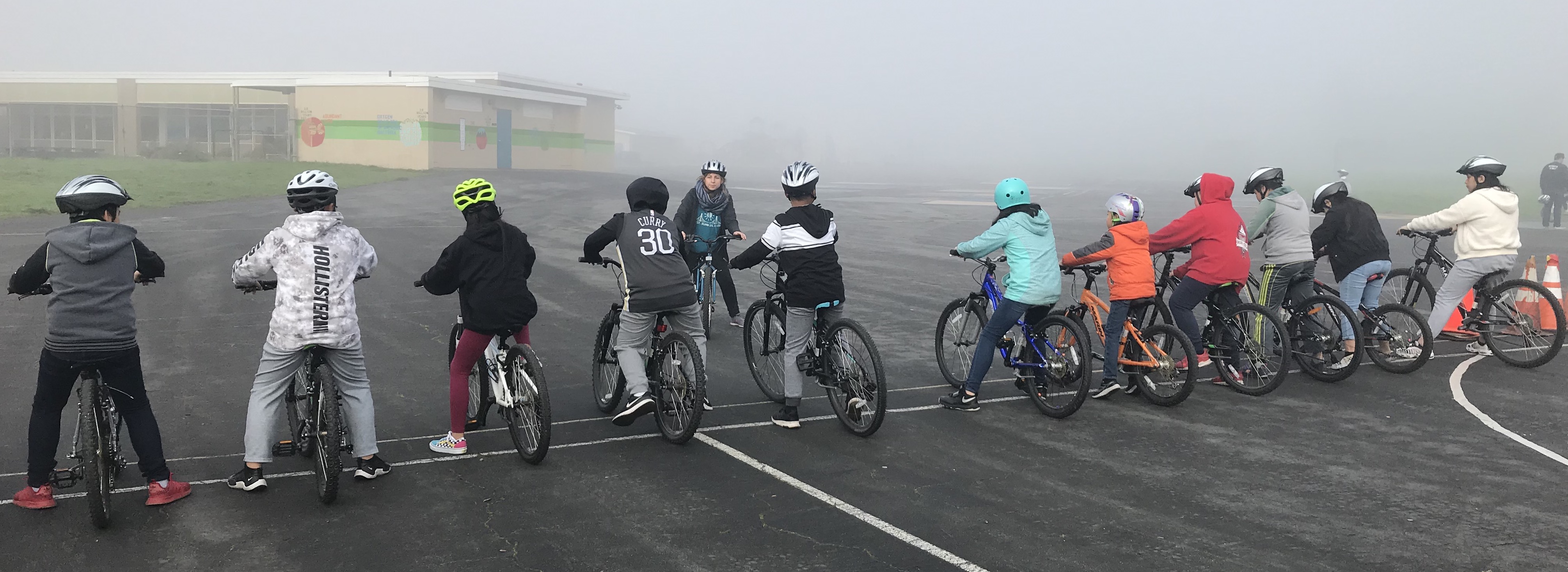 students on bikes lined up in a row on the playground